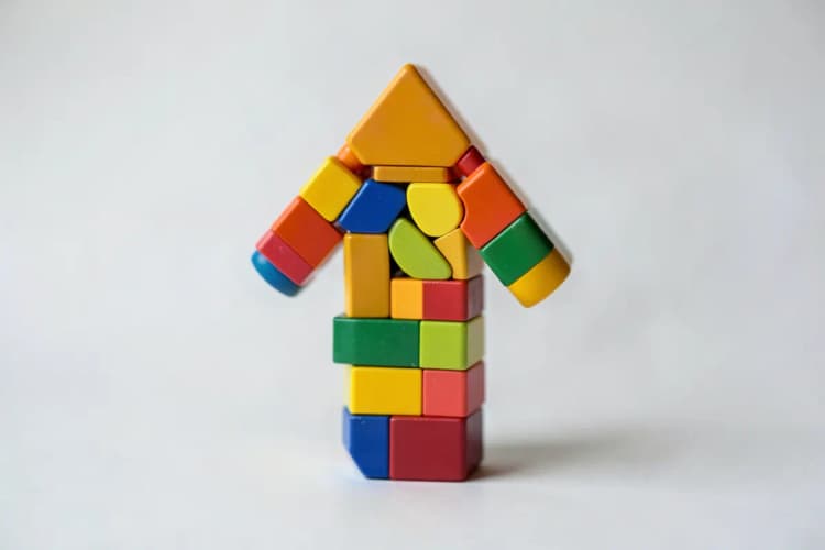 Uma seta apontando para cima feita de blocos de construção coloridos.