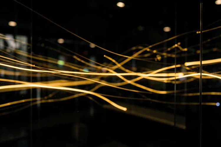 Uma representação visual de tráfego de dados fluindo como luzes em um ambiente escuro, com elementos que remetem a vidro.