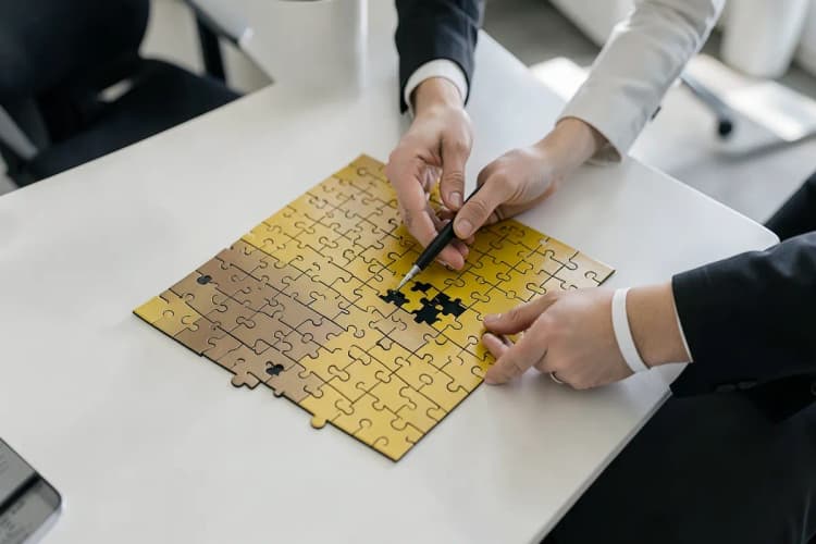 Pessoa montando um quebra-cabeça com peças representando palavras-chave, orçamento e segmentação.