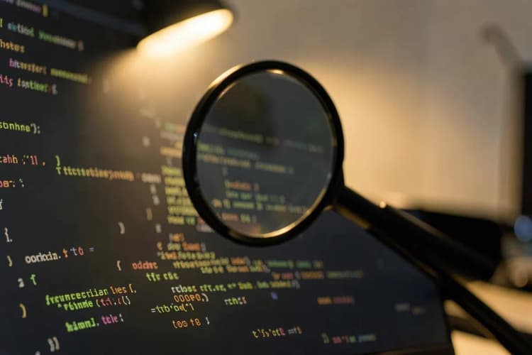 Uma lupa focando em um código de programação em uma tela de computador, representando otimização de SEO.